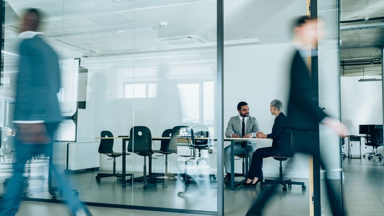 Besprechung in gläsernem Besprechungsraum von außen